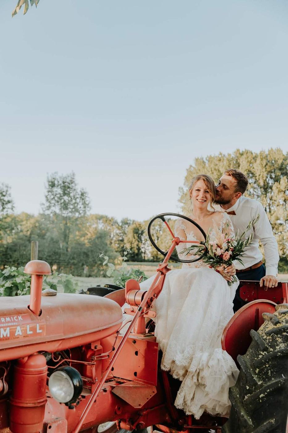 Couple de maries dans une ambiance champetre avec tracteur ancien