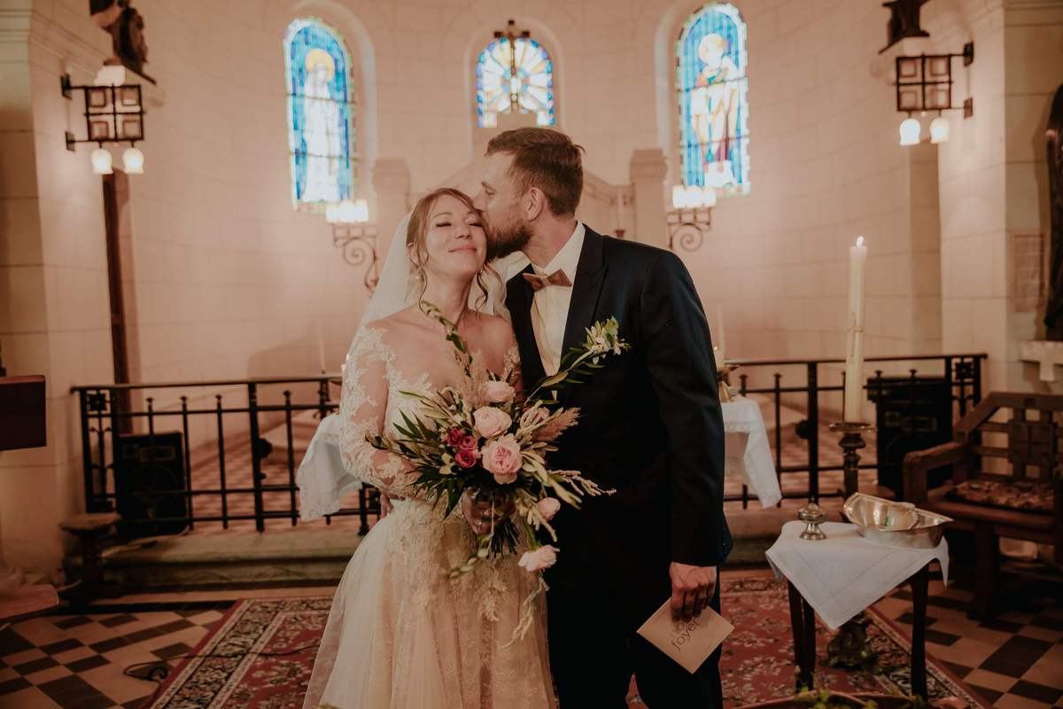Portrait des maries dans une eglise apres un mariage champetre