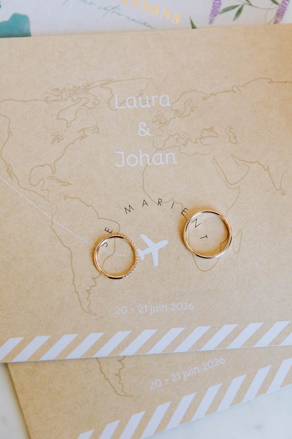 Alliances de Laura et Johan posées sur leur papeterie de mariage