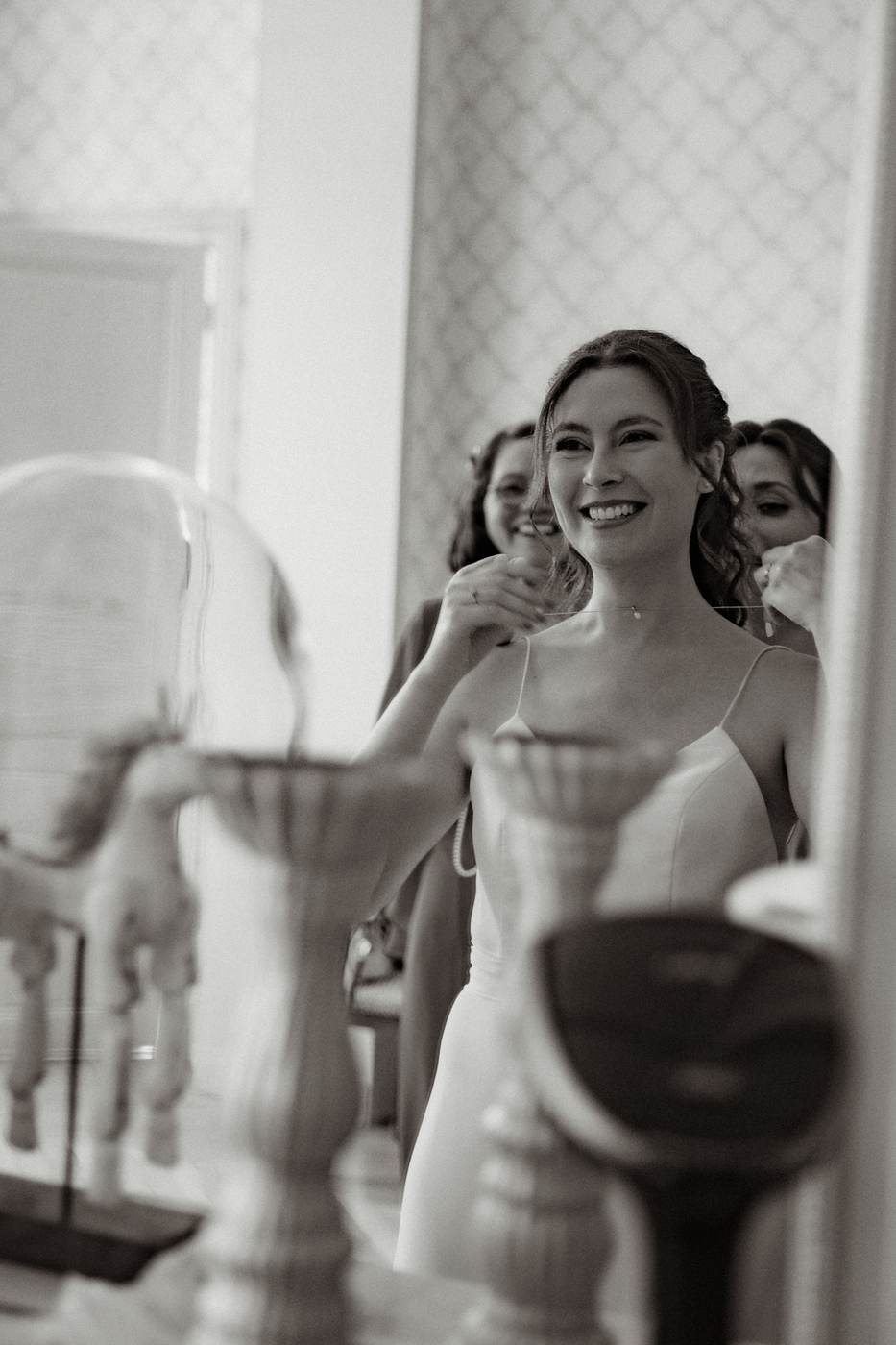 Sourire de la mariée entourée de ses proches en noir et blanc