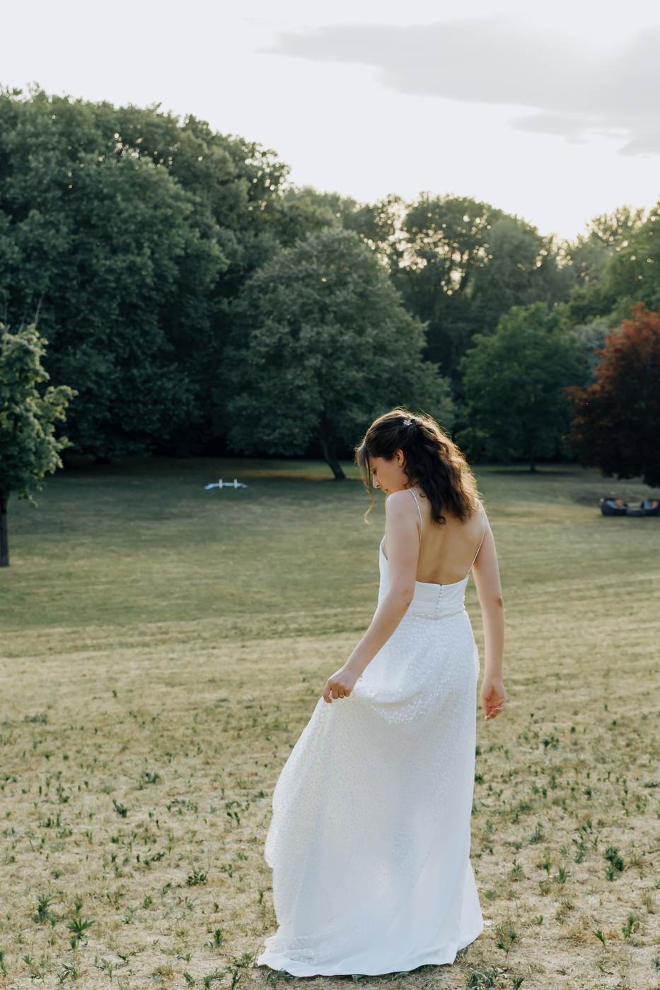 Laura marche seule dans le parc à la lumière de fin de journée