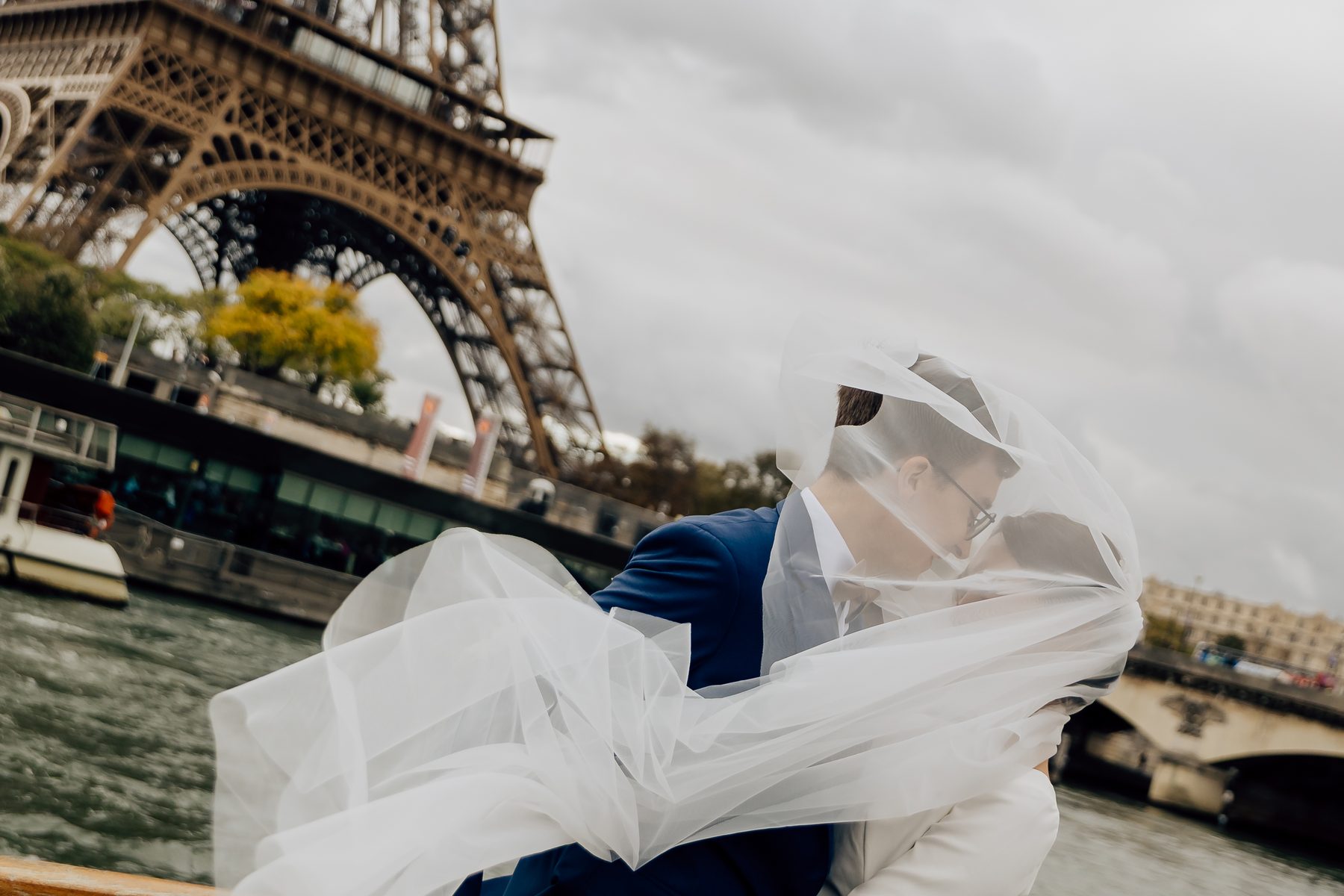 Le voile de la mariée porté par le vent devant la tour Eiffel