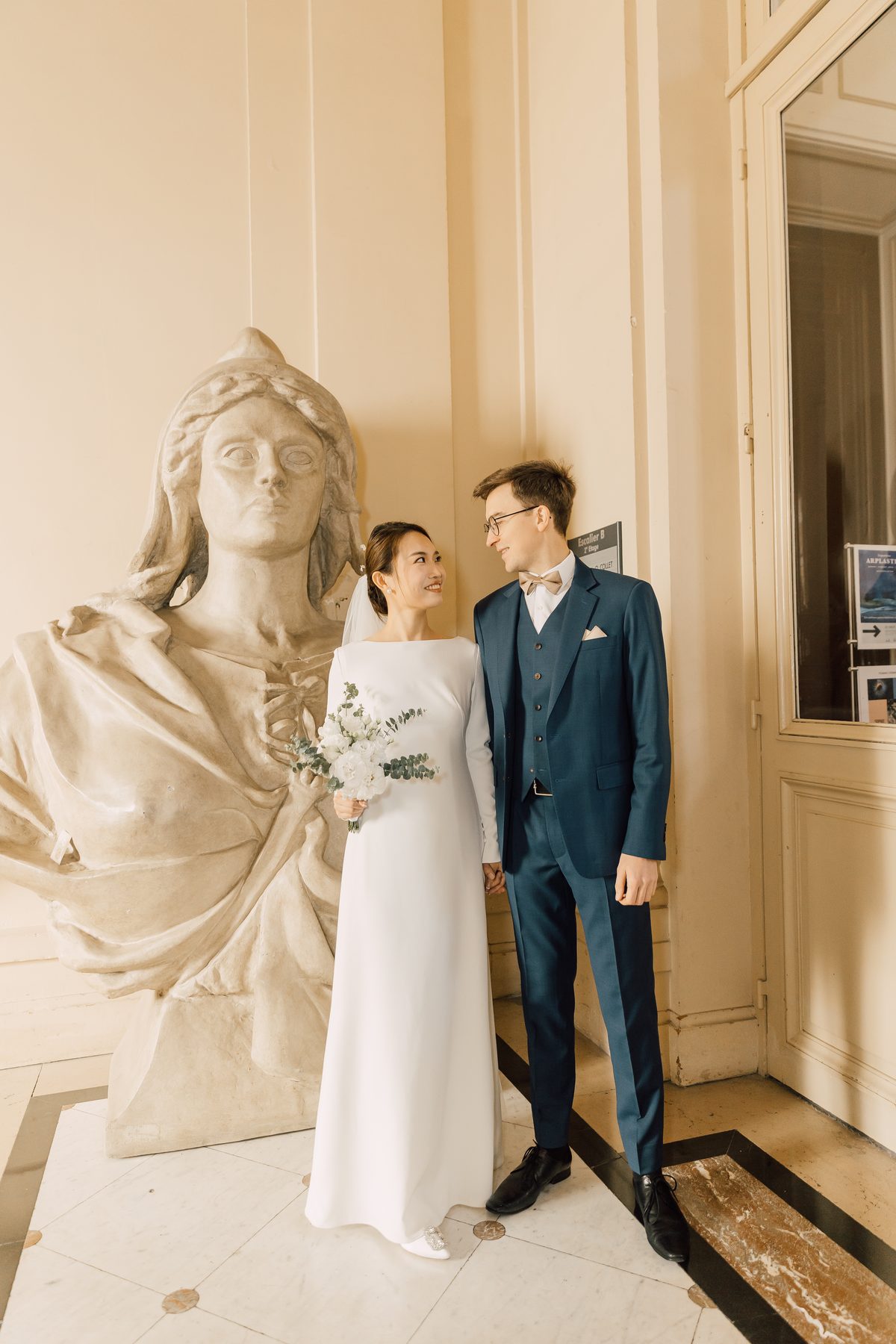 Portrait des mariés dans l'architecture élégante de la mairie du 5e