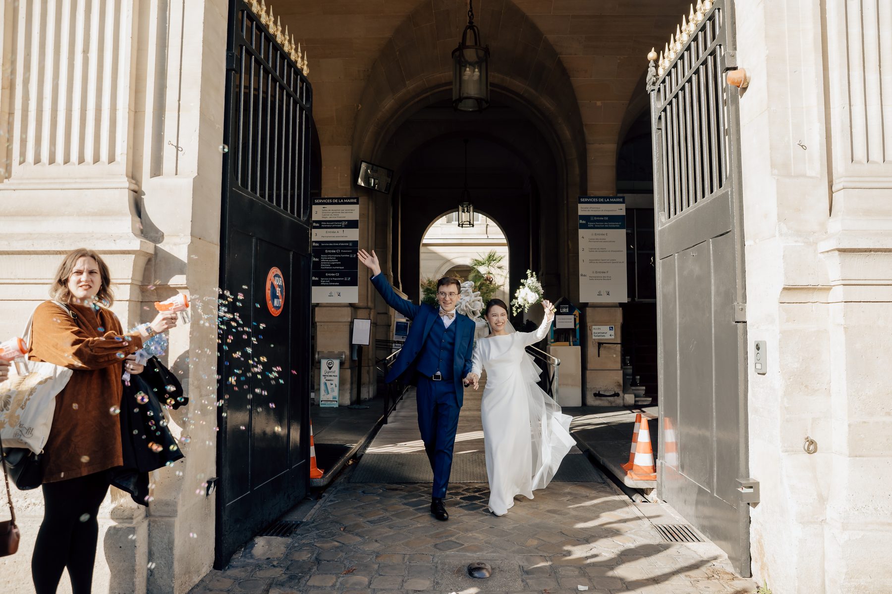 Sortie joyeuse des mariés sous le porche de la mairie