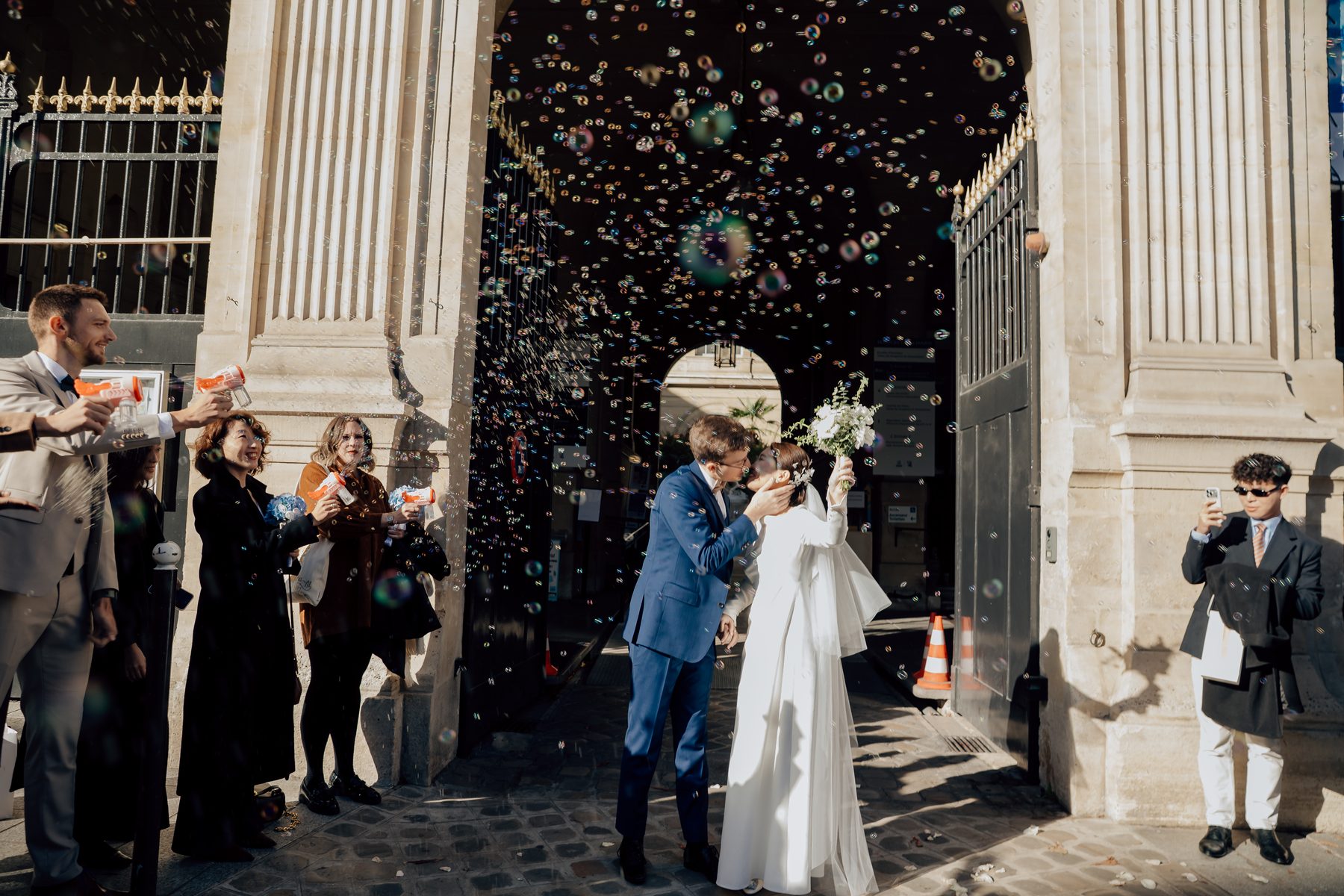 Les mariés entourés de confettis à la sortie de la mairie
