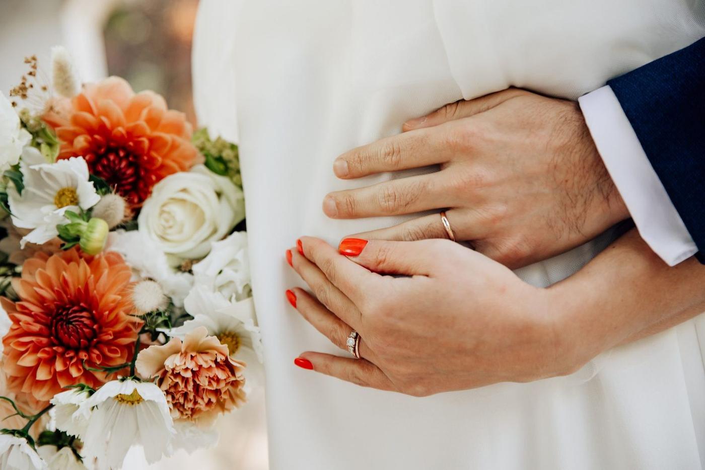 Détail des alliances et du bouquet de mariage au Parc Monceau