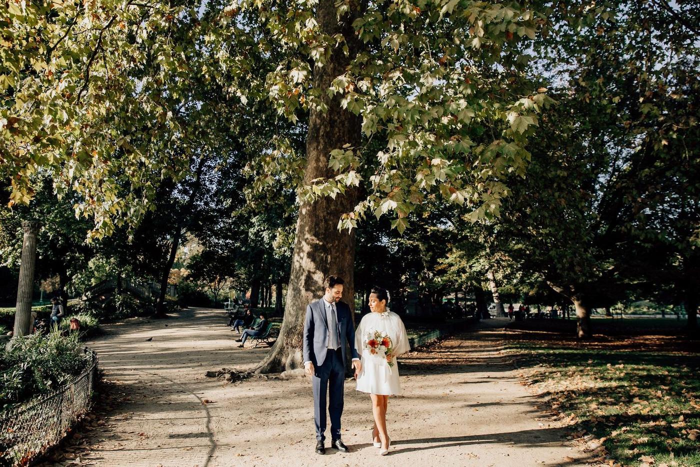 Les mariés marchent sous les arbres du Parc Monceau
