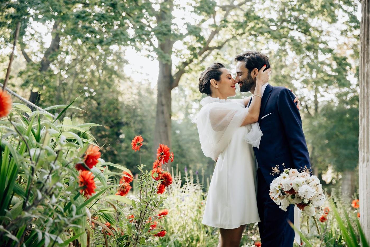 Baiser des mariés dans un décor fleuri du Parc Monceau