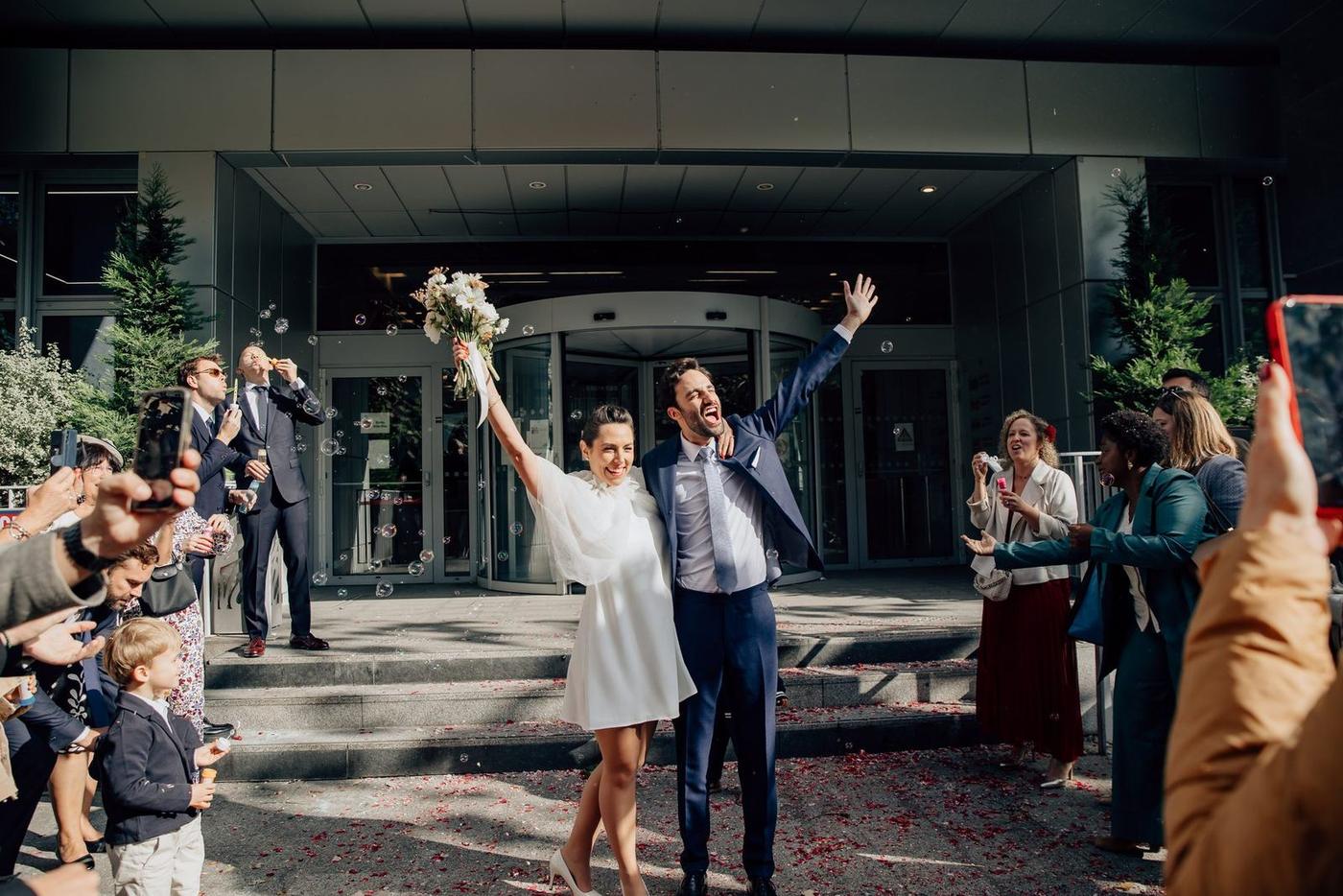 La mariée lève son bouquet devant les invités