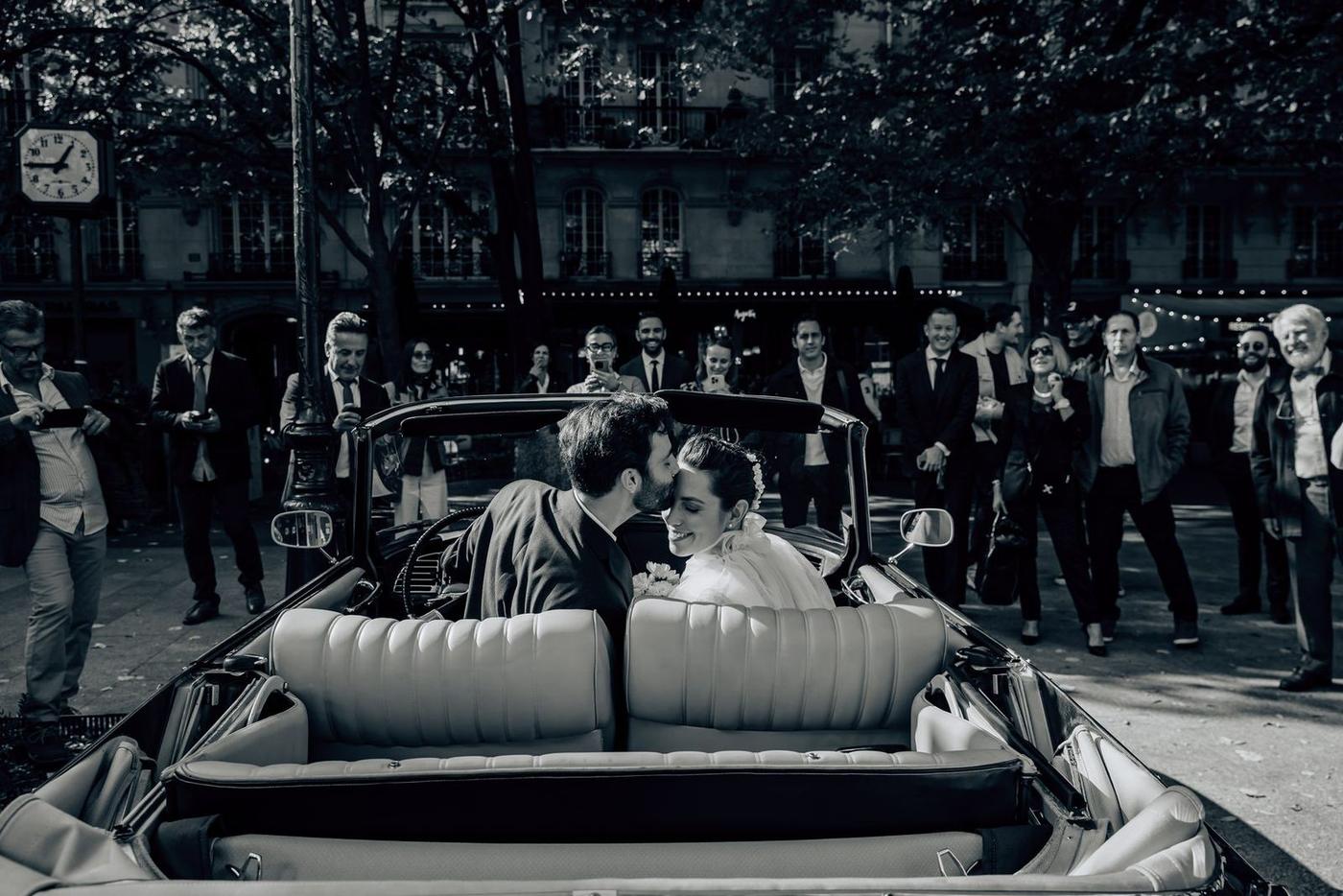 Portrait en noir et blanc des mariés dans une voiture ancienne