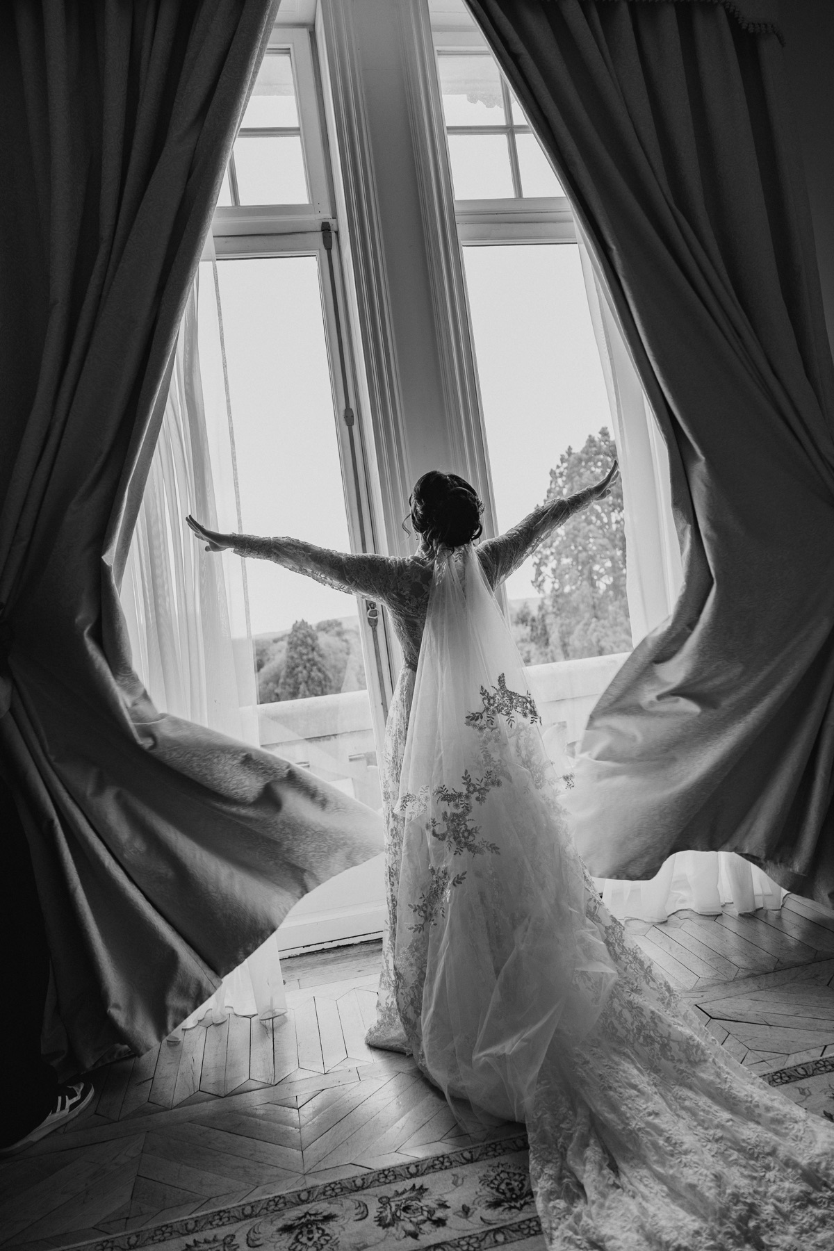 Bride getting ready beside a château window in France