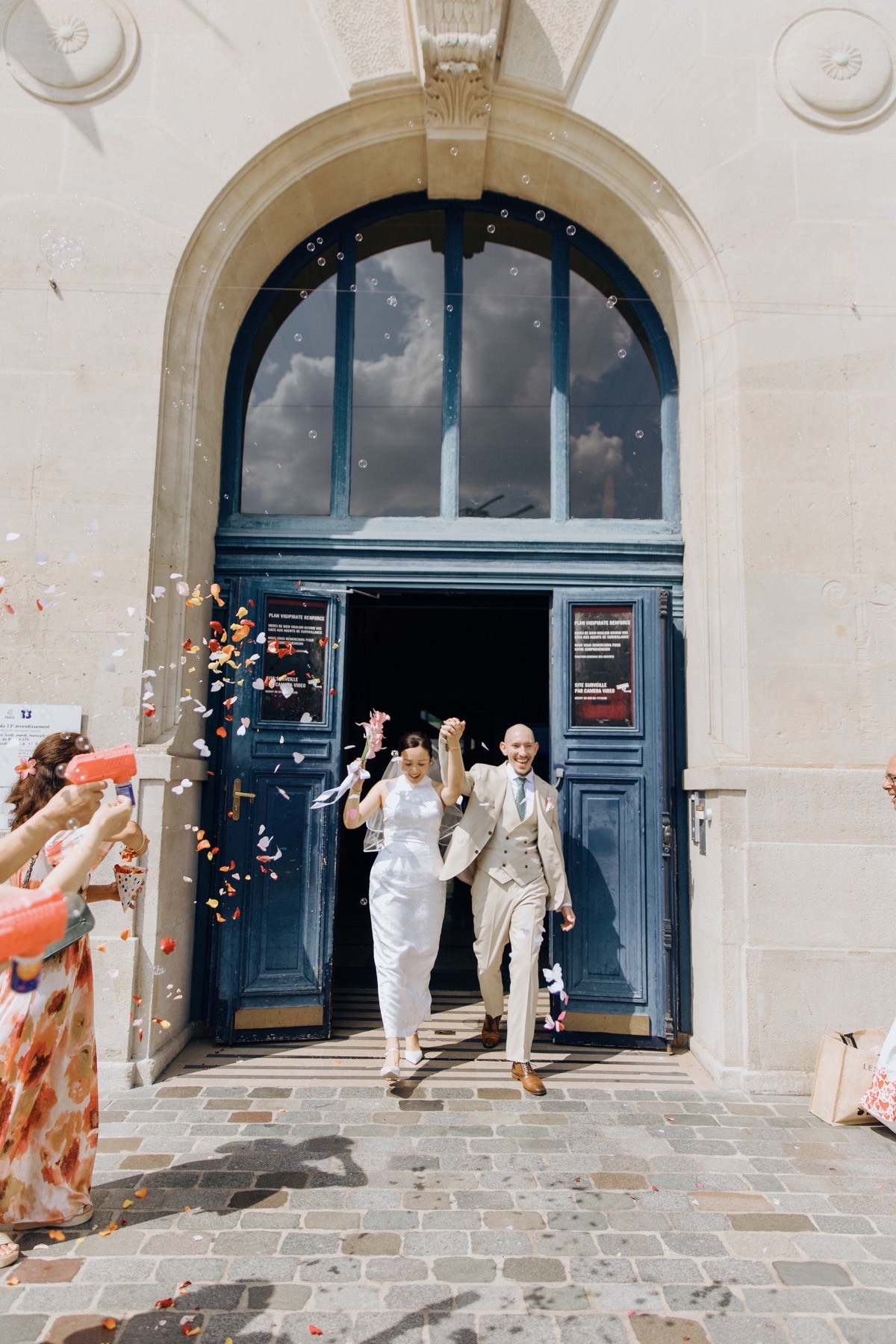 Sortie joyeuse des mariés sous les confettis devant la mairie